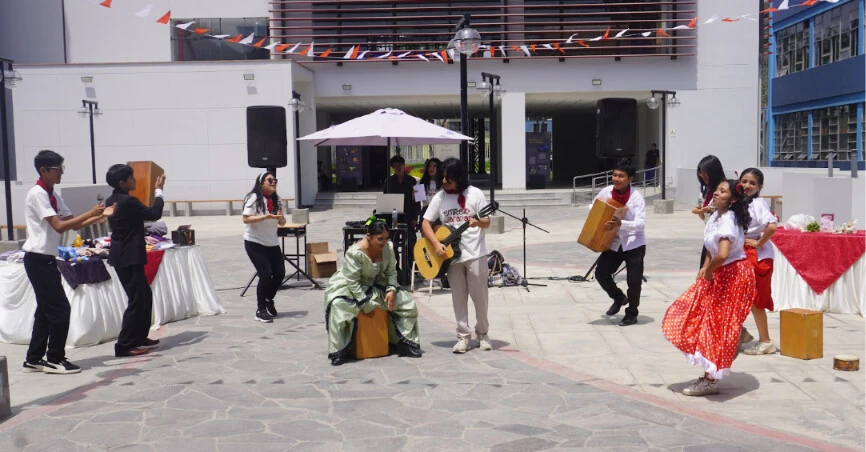 Integrantes de Entre Jaranas bailan y tocan cajón en la explanada de la Facultad de Letras durante la primera activación.