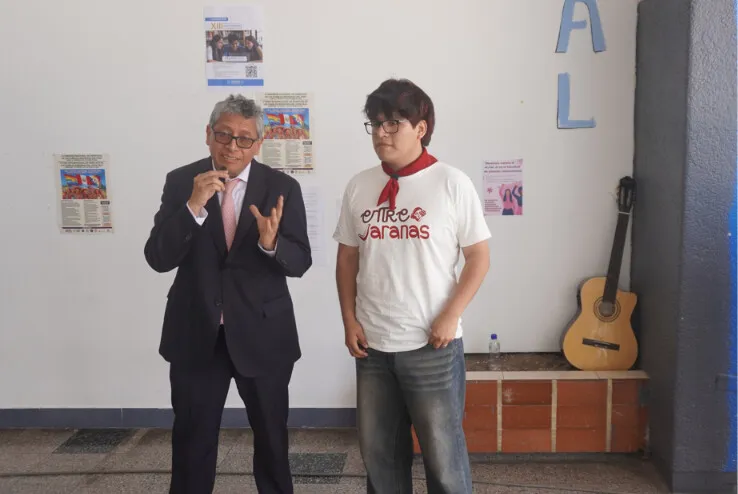 El decano Marcel Martín Velázquez Castro durante su intervención, junto a un integrante de Entre Jaranas.