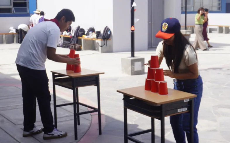 Asistentes compiten apilando vasos en una de las dinámicas de la jornada.